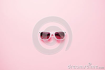 Childrens sunglasses for girls on a pink background. Kids fashion, summer vacation concept. Minimal flat lay. Stock Photo